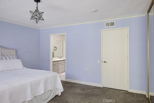 carpeted bedroom featuring crown molding, ensuite bath, a textured ceiling, and visible vents