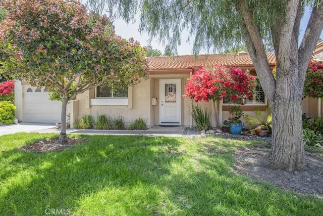 ranch-style house with an attached garage, stucco siding, a front yard, concrete driveway, and a tiled roof