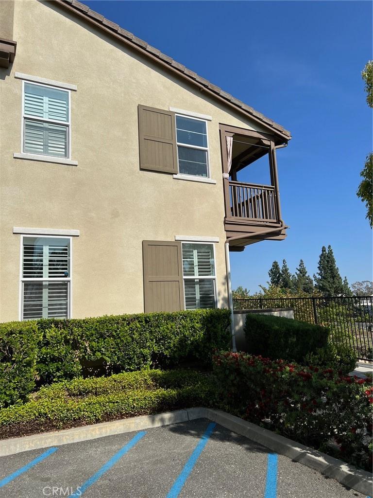 view of property exterior featuring fence, a balcony, and stucco siding