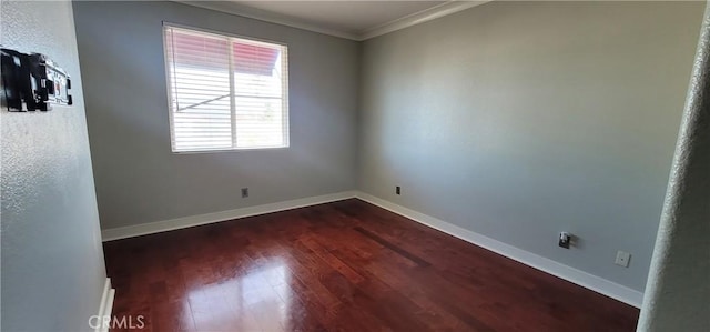 unfurnished room with baseboards, dark wood-style floors, and ornamental molding