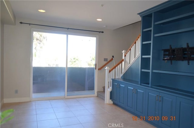 doorway featuring baseboards, recessed lighting, stairs, and light tile patterned floors