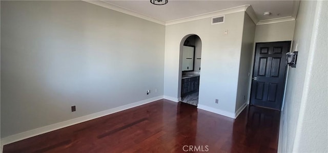 unfurnished room featuring crown molding, arched walkways, dark wood-style floors, and visible vents