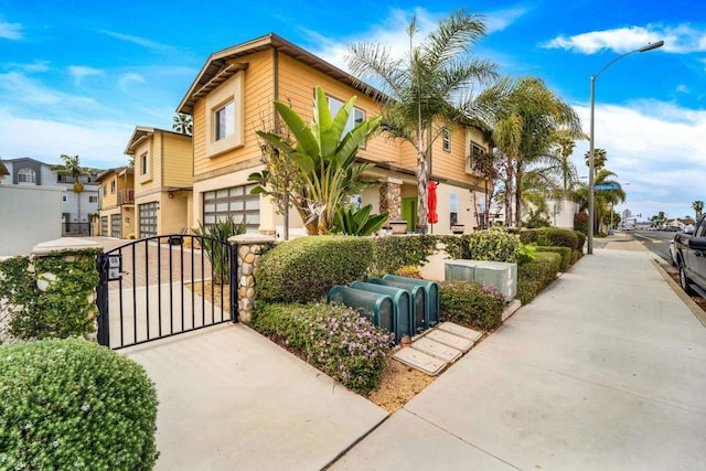 view of front of house featuring a garage, a gate, and a residential view