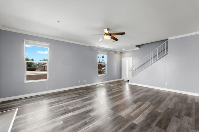 empty room with ceiling fan, crown molding, wood finished floors, stairway, and baseboards