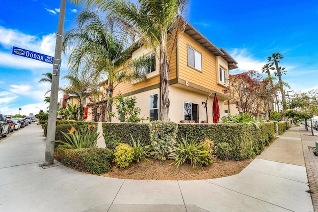 view of side of property with fence and stucco siding
