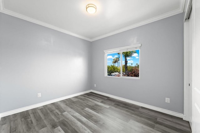 spare room with baseboards, ornamental molding, and dark wood-type flooring