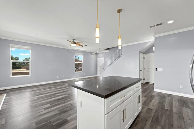kitchen featuring a ceiling fan, visible vents, crown molding, dark countertops, and dark wood-style floors