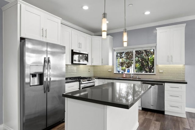 kitchen featuring a sink, appliances with stainless steel finishes, dark countertops, and white cabinetry