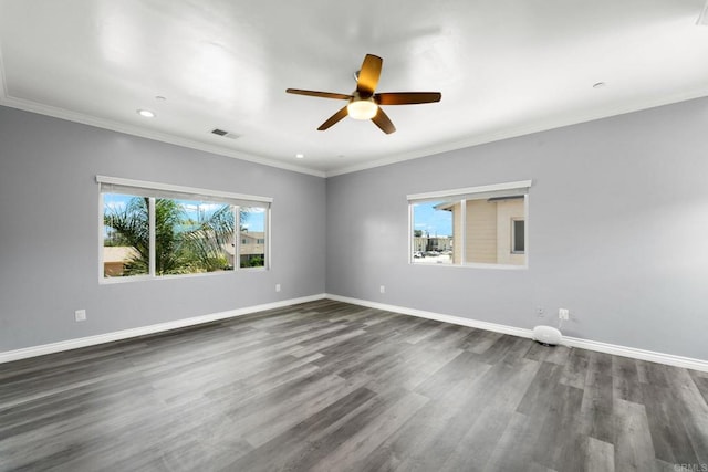 spare room with visible vents, dark wood-type flooring, ceiling fan, and a wealth of natural light