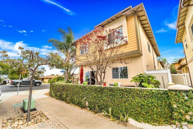 view of front of home featuring stucco siding and fence