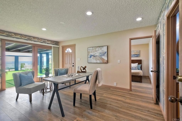 dining space featuring recessed lighting, a textured ceiling, and wood finished floors