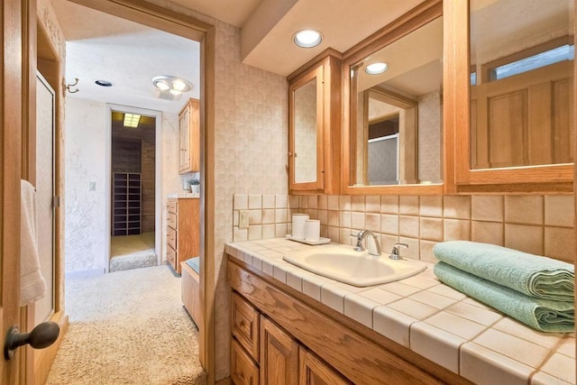 full bath with vanity, a textured wall, a shower with door, recessed lighting, and backsplash
