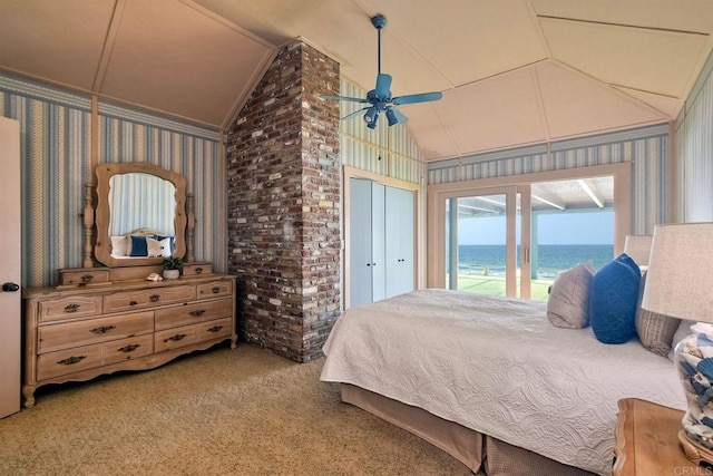 bedroom featuring carpet floors, wallpapered walls, access to outside, a water view, and vaulted ceiling