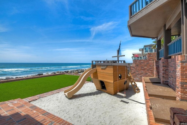 view of playground with a beach view and a water view