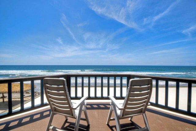 balcony featuring a water view and a beach view