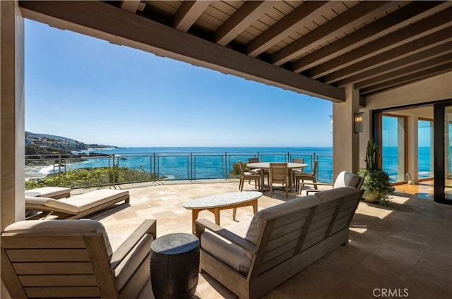 balcony with a water view, a patio area, and outdoor dining space