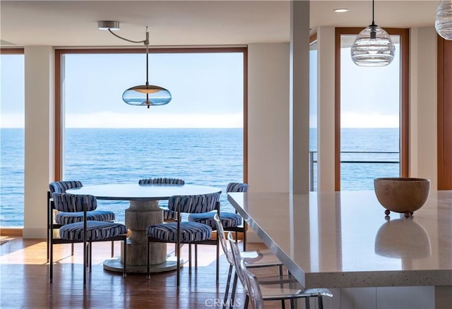 dining space with expansive windows, plenty of natural light, and a water view