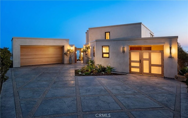 contemporary home with a garage and stucco siding