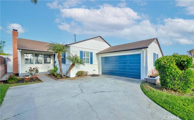 single story home featuring a garage, stucco siding, a chimney, and driveway