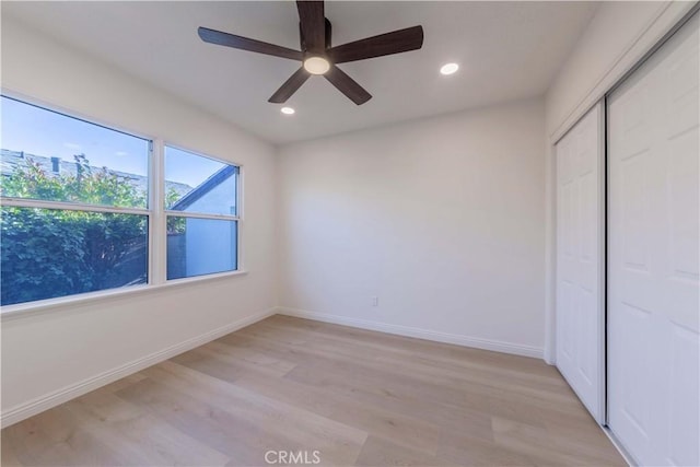 unfurnished bedroom featuring light wood-type flooring, recessed lighting, baseboards, and a closet