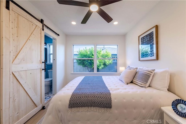 bedroom featuring recessed lighting, a barn door, a ceiling fan, and wood finished floors