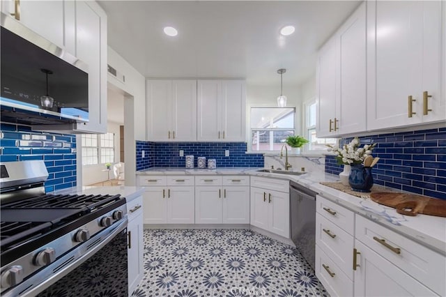 kitchen featuring a sink, backsplash, white cabinets, and stainless steel appliances