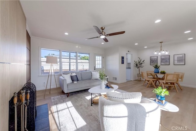 living area featuring baseboards, ceiling fan with notable chandelier, recessed lighting, and light wood-style flooring