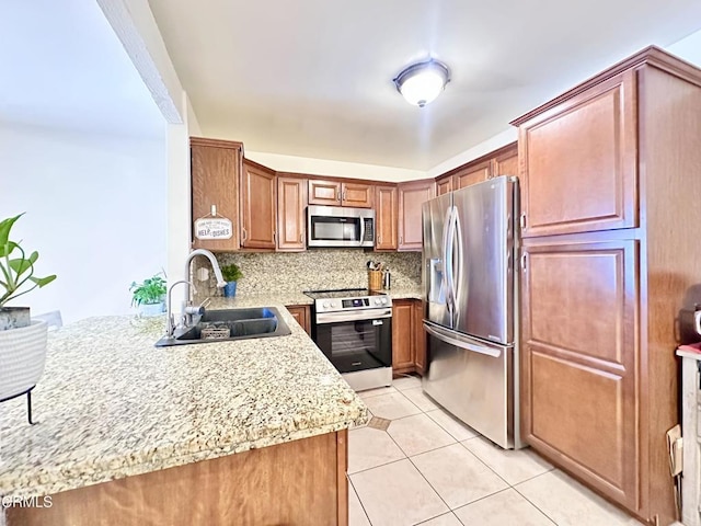 kitchen featuring a sink, brown cabinetry, stainless steel appliances, light tile patterned floors, and backsplash