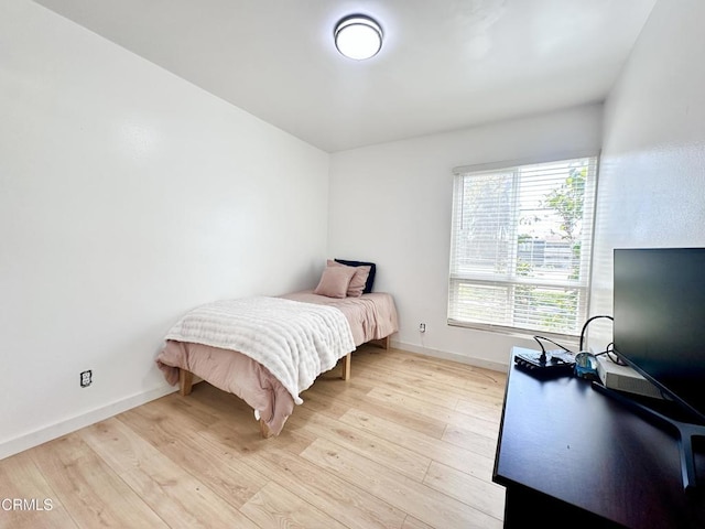 bedroom featuring baseboards and light wood finished floors