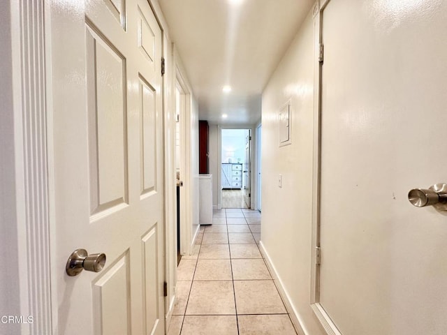 corridor with recessed lighting, baseboards, and light tile patterned floors