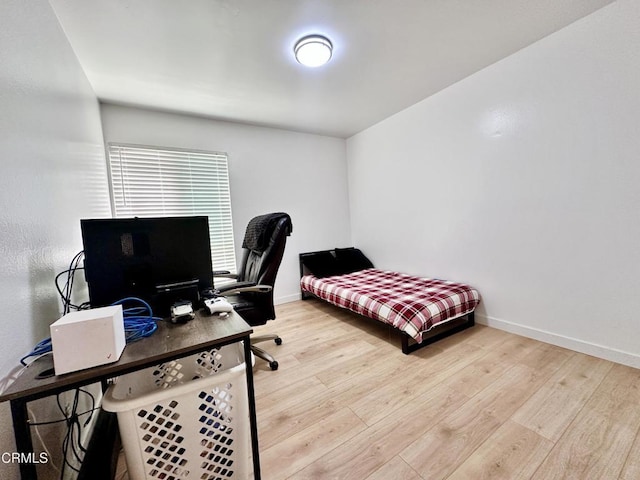 bedroom featuring baseboards and wood finished floors