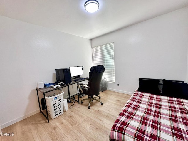 bedroom with baseboards and wood finished floors