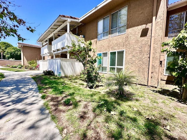 view of home's exterior with fence and stucco siding