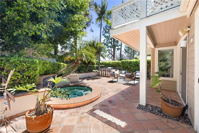 view of patio / terrace featuring an in ground hot tub, outdoor lounge area, and a balcony