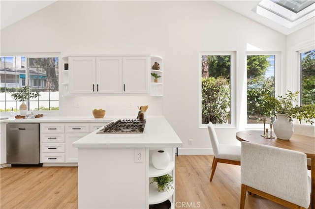kitchen with light countertops, appliances with stainless steel finishes, open shelves, and light wood-style flooring