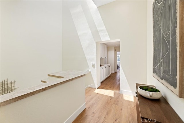 hallway with baseboards and light wood-style flooring