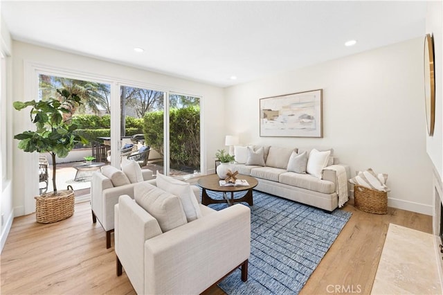 living area with recessed lighting, baseboards, and wood finished floors