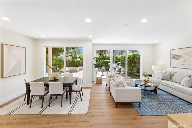 living room with recessed lighting, baseboards, and light wood finished floors