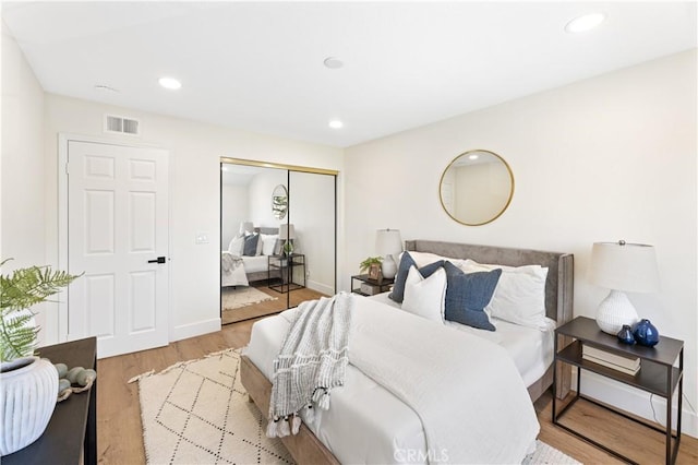 bedroom featuring visible vents, recessed lighting, wood finished floors, and a closet