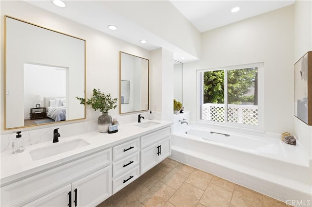 ensuite bathroom featuring a sink, double vanity, ensuite bath, and a bath