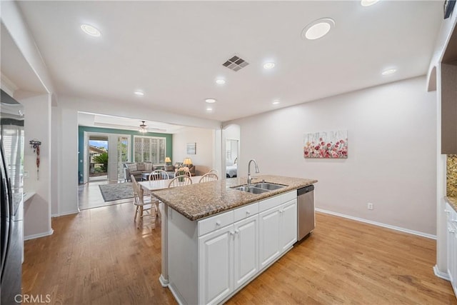 kitchen with visible vents, baseboards, white cabinetry, a sink, and appliances with stainless steel finishes
