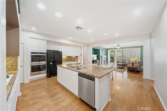 kitchen featuring a sink, stainless steel appliances, light wood-type flooring, and visible vents