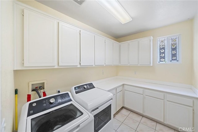 washroom with light tile patterned floors, separate washer and dryer, cabinet space, and visible vents