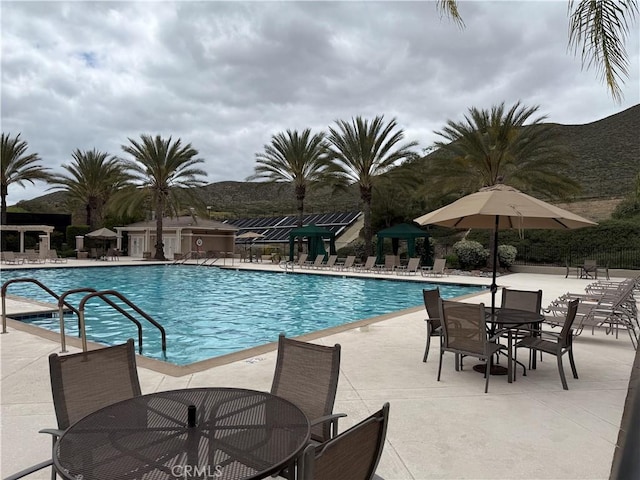 community pool featuring a patio and outdoor dining space