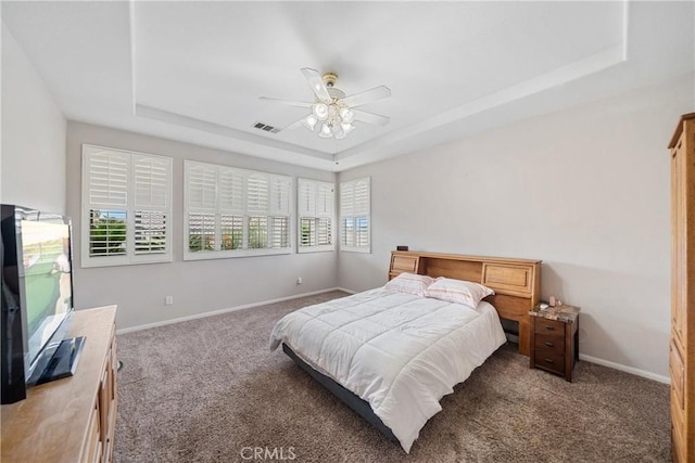 bedroom with a raised ceiling, baseboards, carpet floors, and visible vents