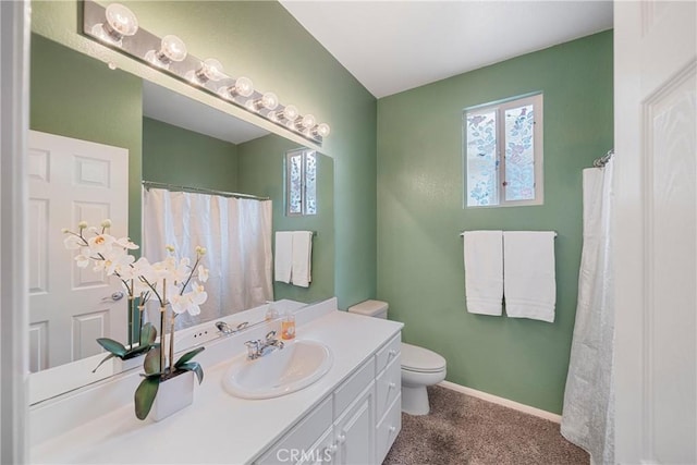bathroom with toilet, baseboards, a healthy amount of sunlight, and vanity