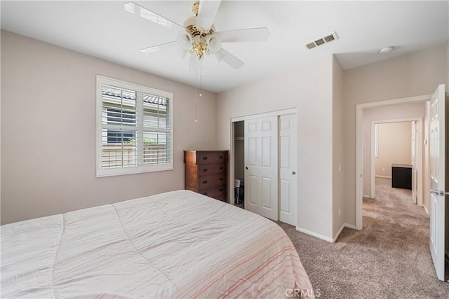 carpeted bedroom with baseboards, a ceiling fan, a closet, and visible vents