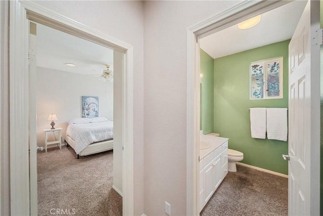 bathroom with vanity, baseboards, toilet, and ceiling fan