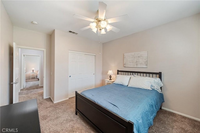 bedroom featuring baseboards, light carpet, a closet, and visible vents