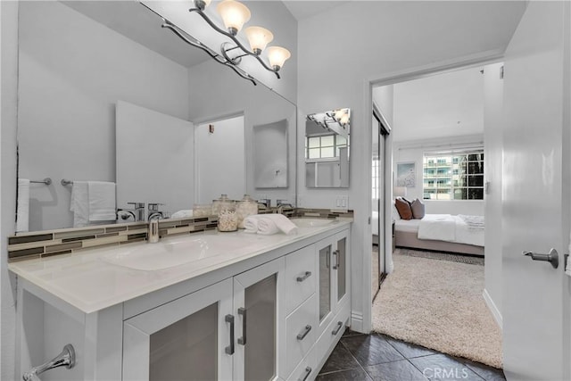 full bathroom with double vanity, a sink, connected bathroom, and an inviting chandelier